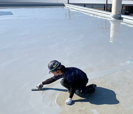 手作業で防水施工する作業員