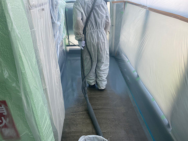 解放廊下で超速硬化ウレタンスプレー吹き付ける作業員