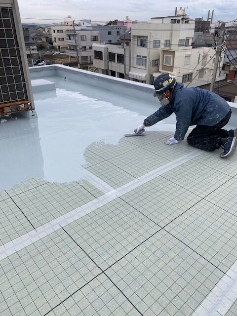 一層目のウレタン防水処理をする作業員