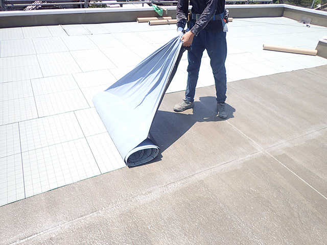 防水工事用にシートを張る作業員
